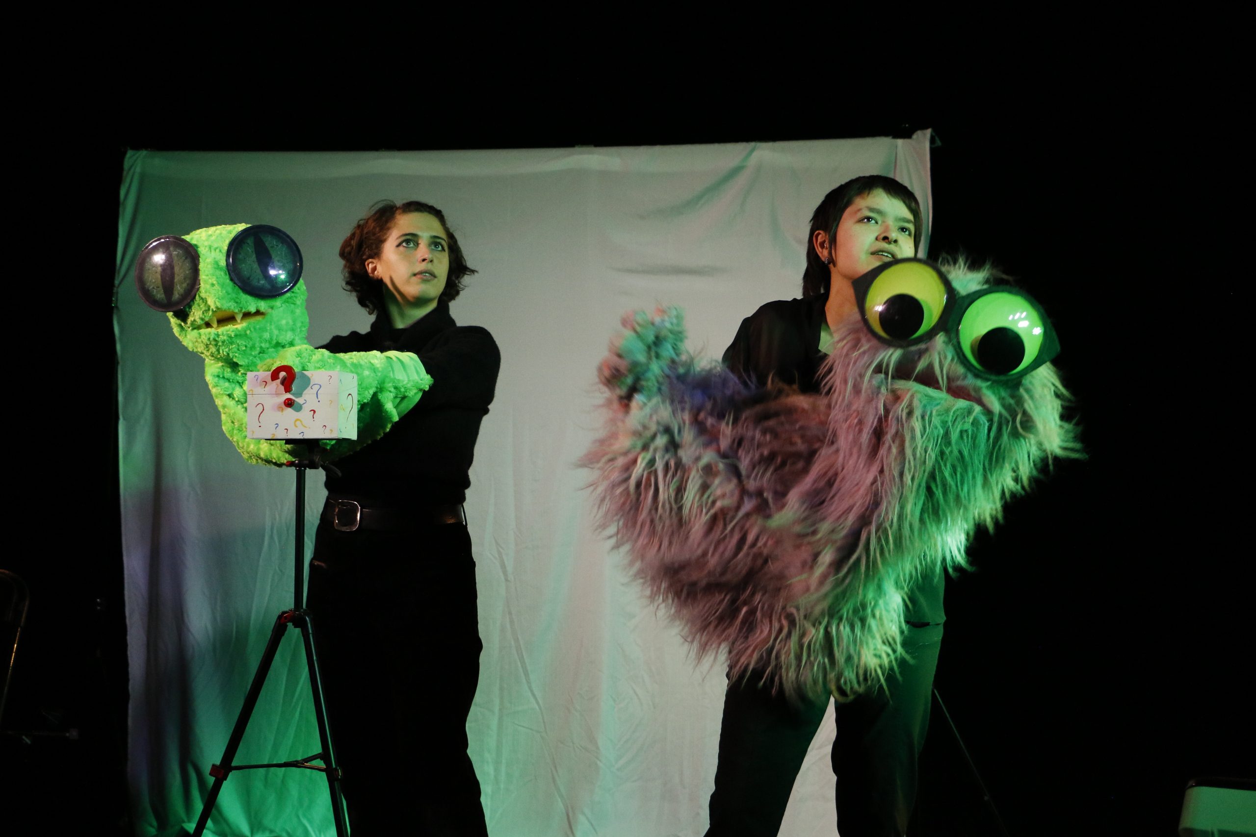 Photo of Loreto and Ty holding the puppets Chlamydia and Gonorrhea in the middle of a scene.